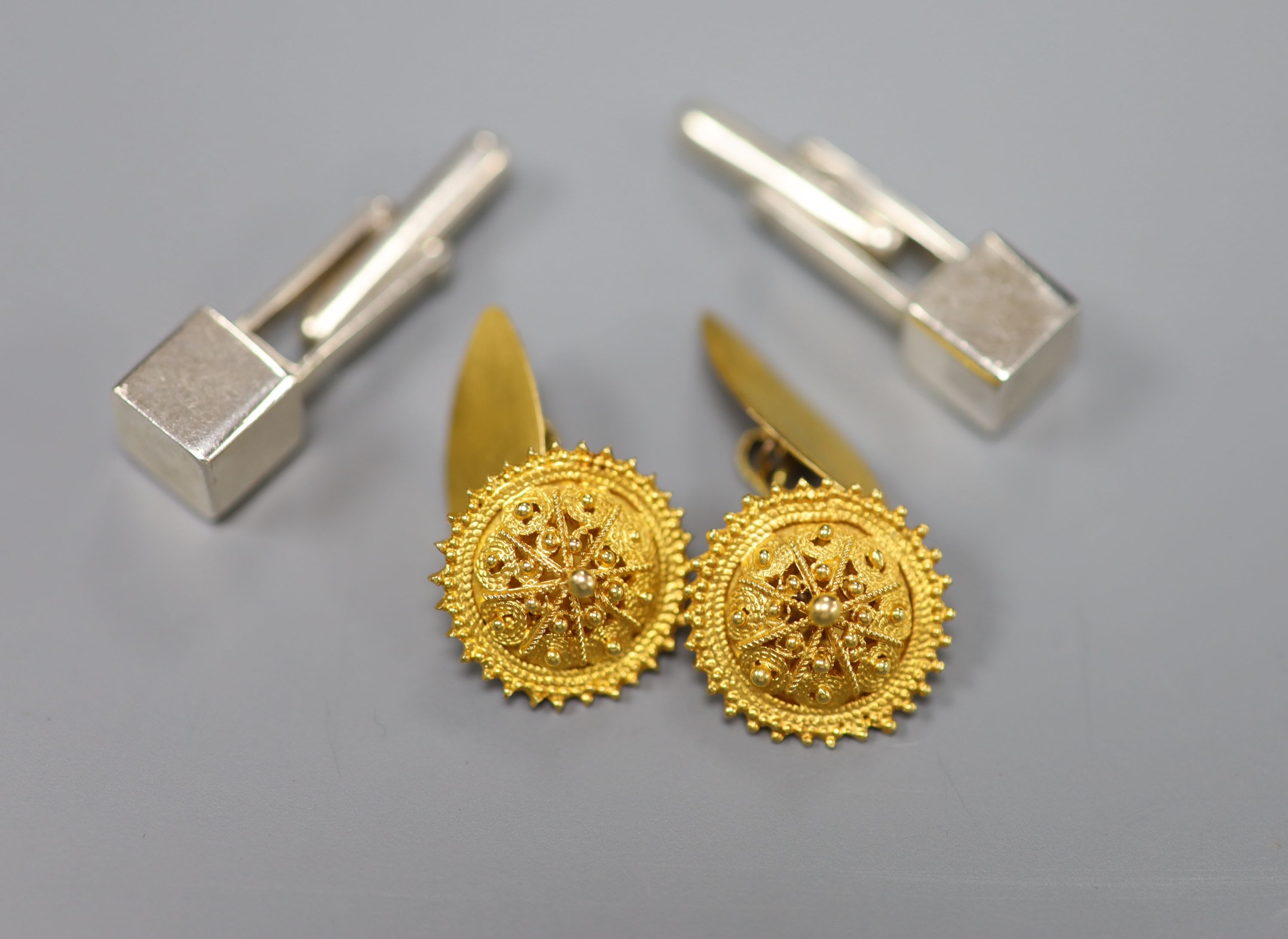 A pair of yellow metal cannetile work cufflinks, gross 6.8 grams and a pair of Peruvian Ilaria 950 white metal cufflinks.